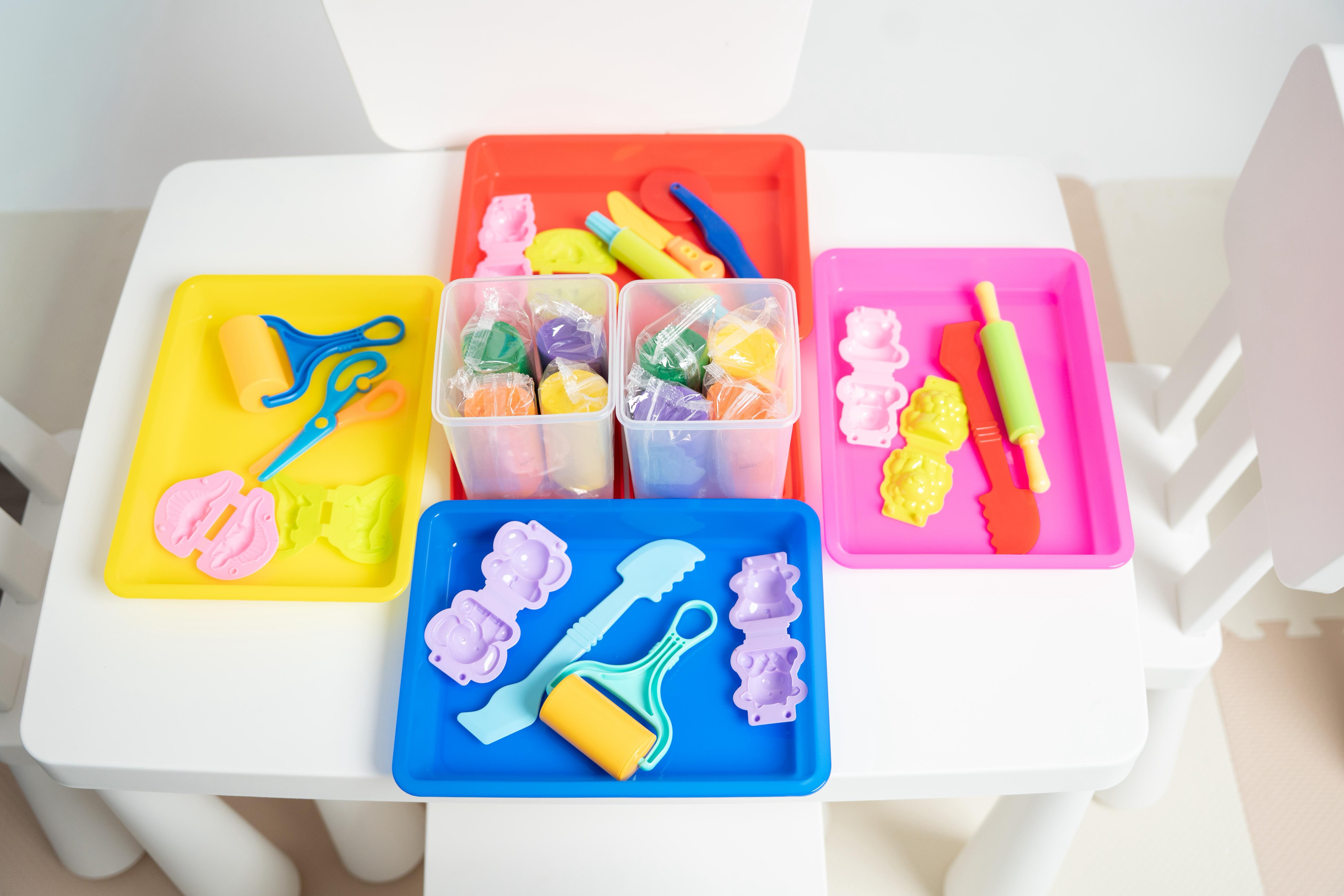 Play-Doh table setup with rainbow Play-Doh, molds and shape cutters